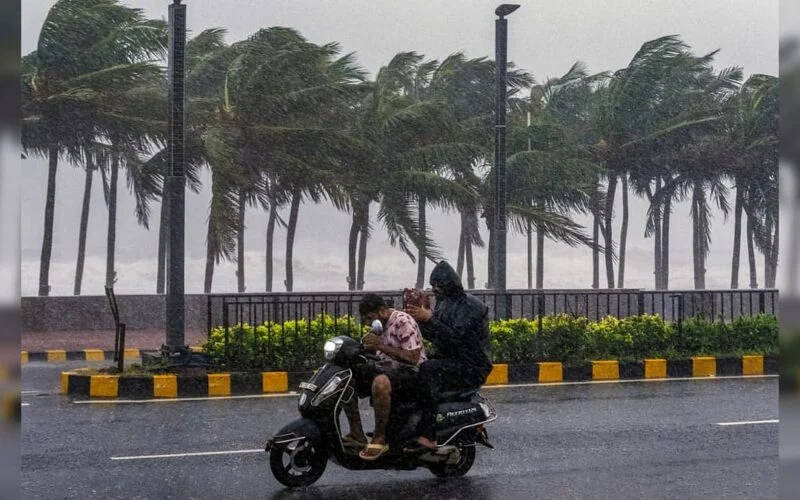 Commuters wading through rain water on a road in Visakhapatnam