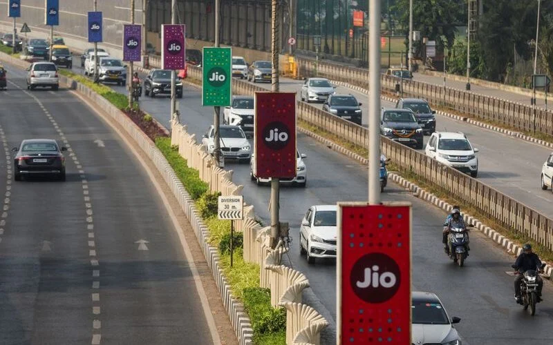 Traffic moves past Jio advertisement boards in Mumbai ahead of the Jio Platforms IPO listing