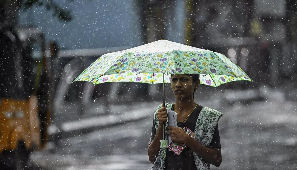 A person carrying an umbrella walks in the rain